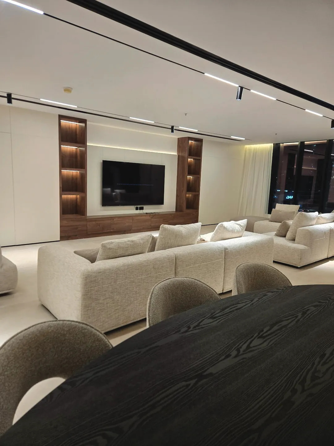 Completed living space with walnut TV wall joinery and linear lighting